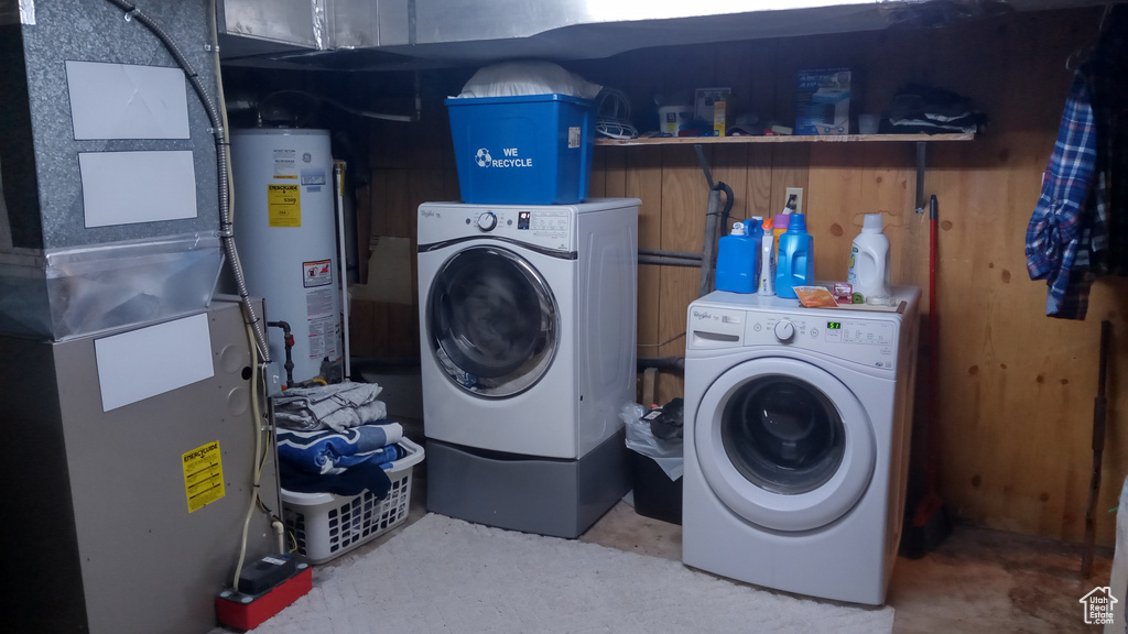 Clothes washing area featuring water heater and washing machine and dryer