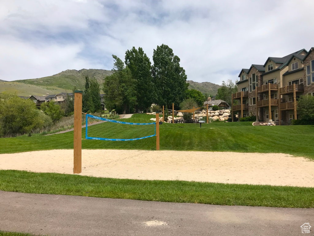 Surrounding community with volleyball court, a mountain view, and a yard