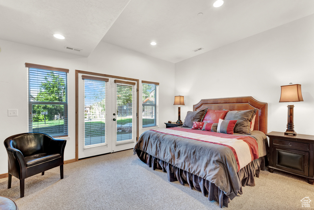 Bedroom with light carpet, multiple windows, and access to exterior