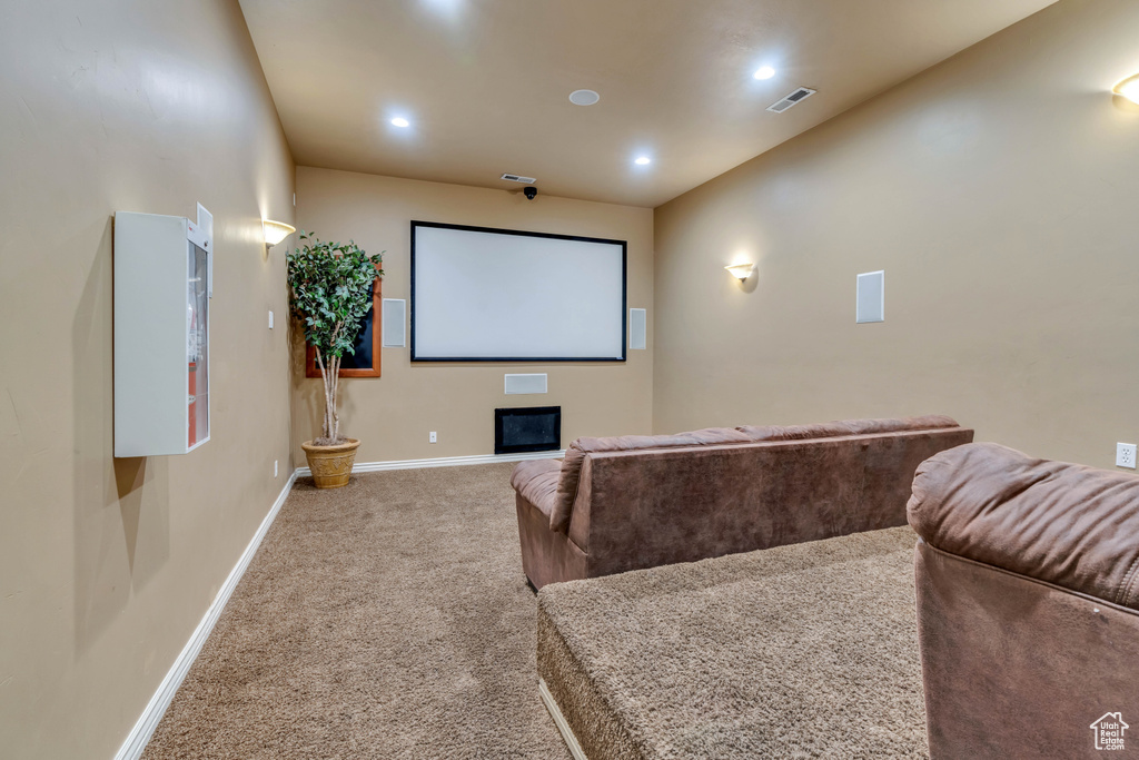 Carpeted home theater room featuring a fireplace