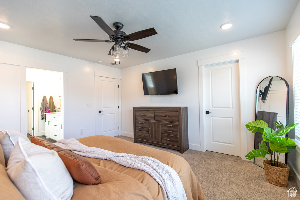 Bedroom featuring light colored carpet, ceiling fan, and ensuite bath