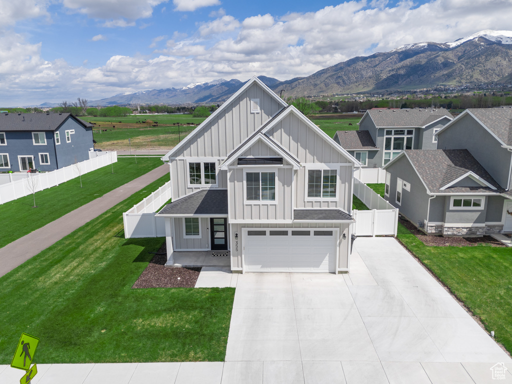 View of front facade with a front lawn, a mountain view, and a garage