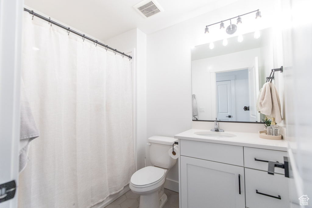 Bathroom featuring tile floors, oversized vanity, and toilet