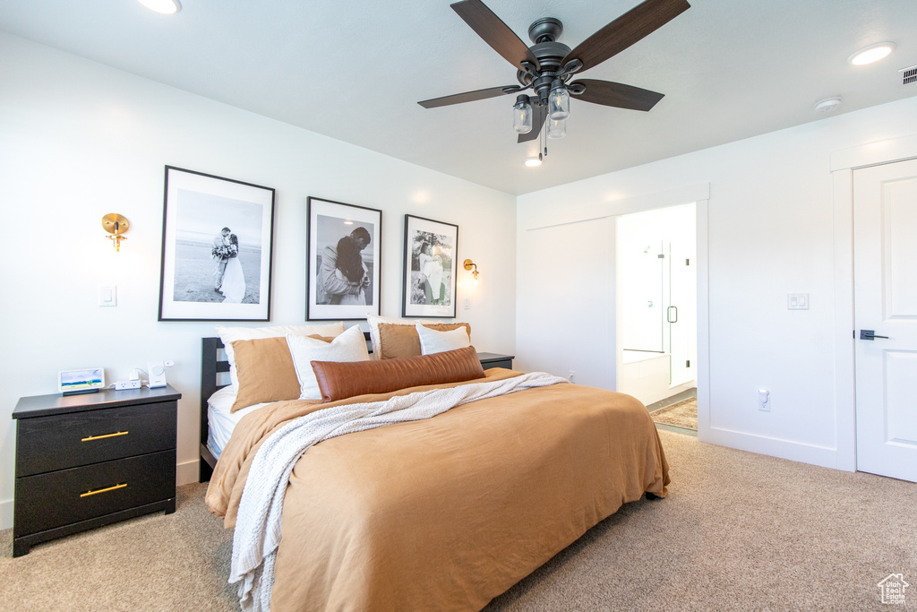 Bedroom featuring light colored carpet, connected bathroom, and ceiling fan