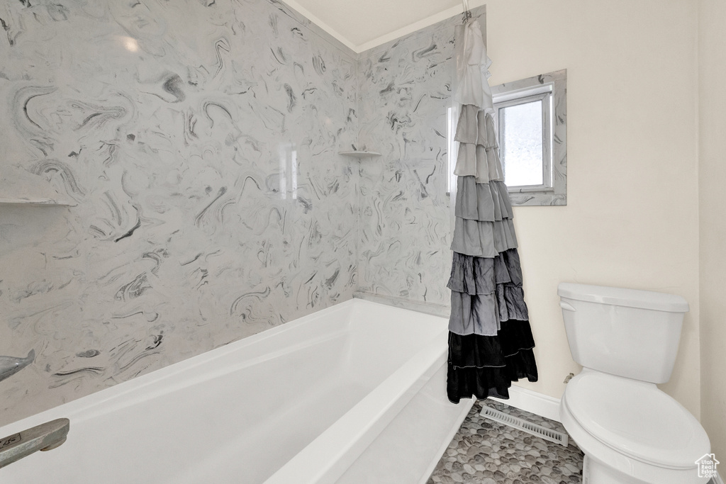 Bathroom featuring bathtub / shower combination, tile floors, and toilet