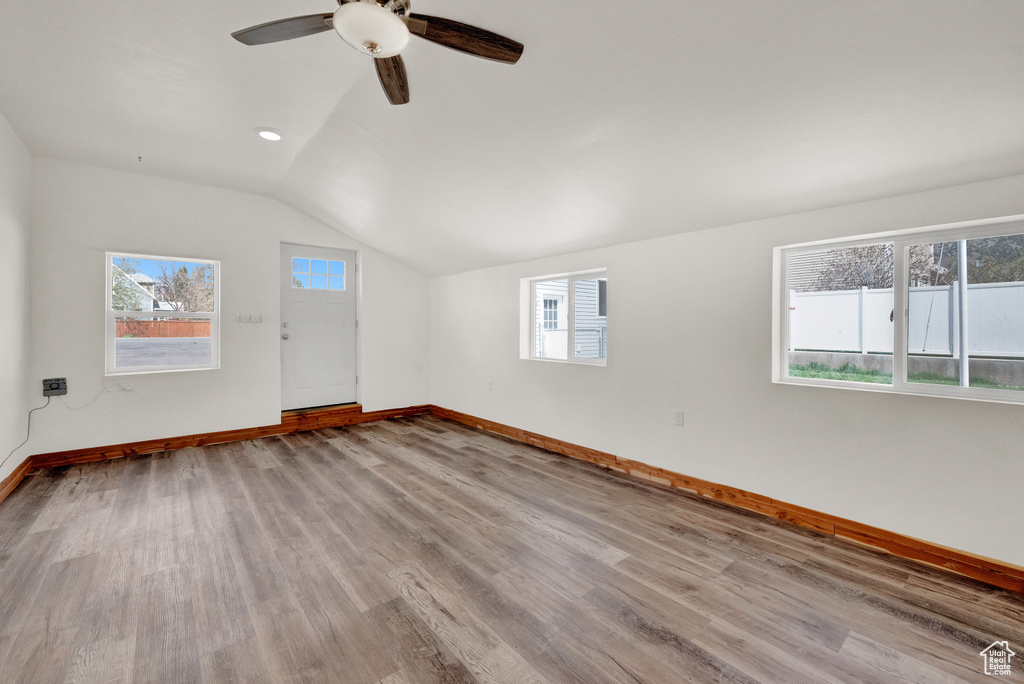 Empty room featuring light hardwood / wood-style floors, ceiling fan, and vaulted ceiling