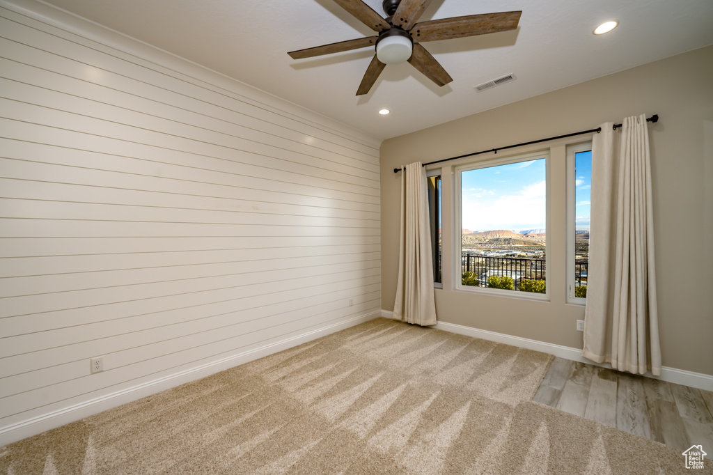 Unfurnished room featuring light colored carpet and ceiling fan