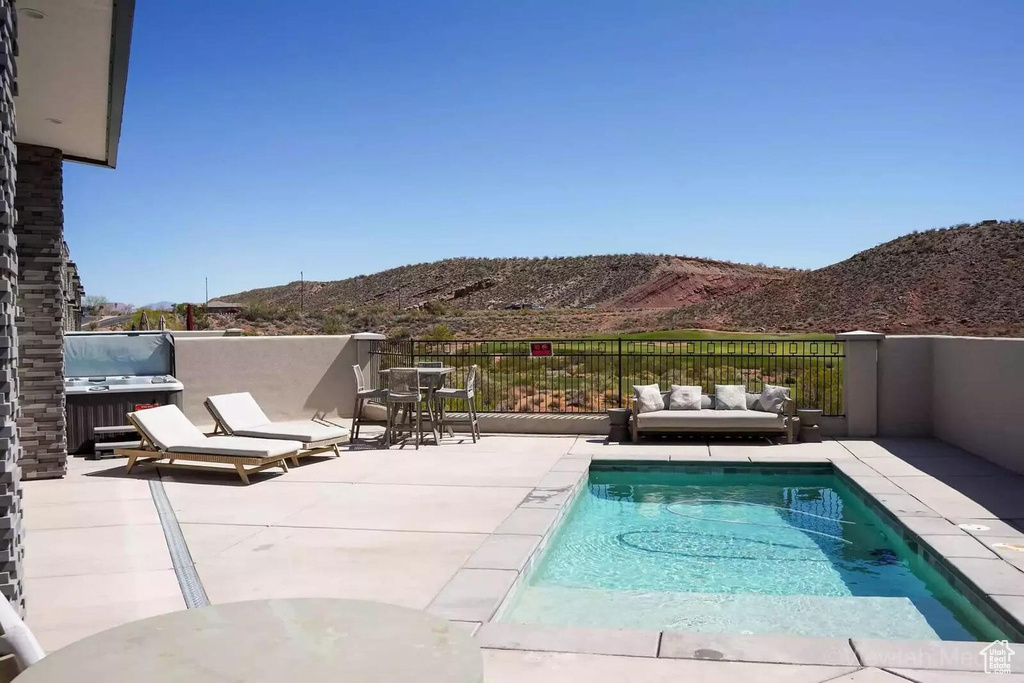 View of swimming pool with a mountain view, a grill, and a patio area