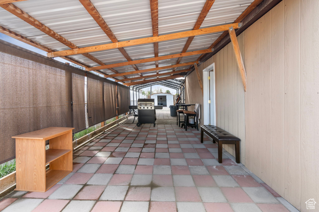View of terrace featuring area for grilling and a storage unit