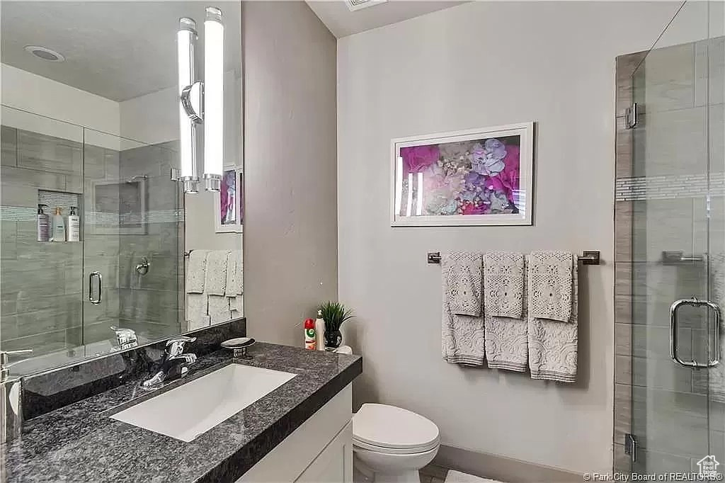 Bathroom with walk in shower, toilet, and oversized vanity