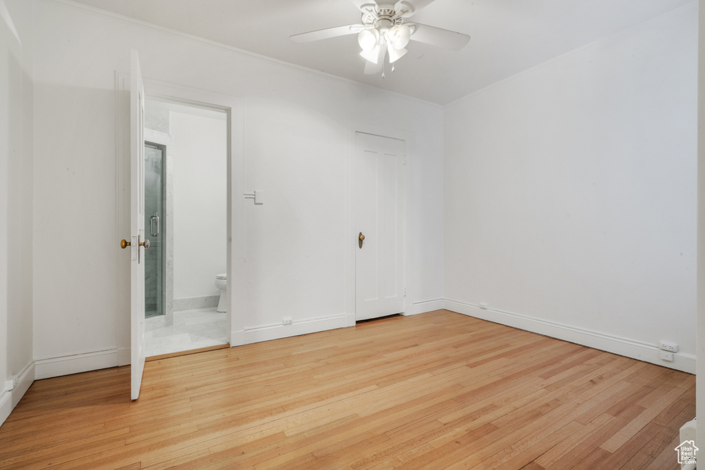 Unfurnished bedroom with light hardwood / wood-style floors, ceiling fan, and ensuite bathroom