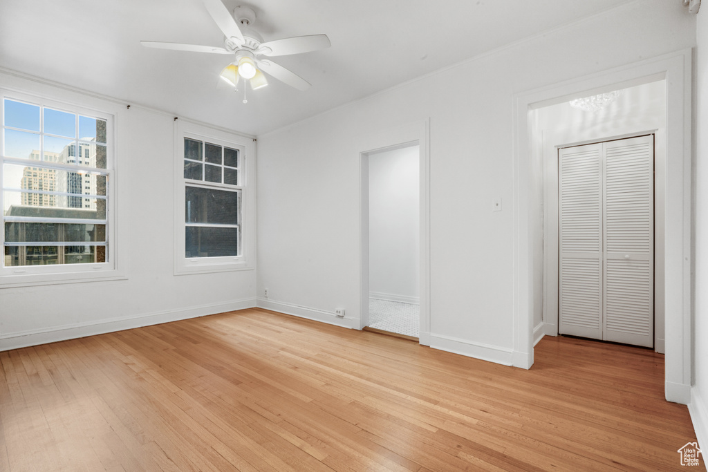 Unfurnished bedroom featuring a closet, ceiling fan, and light wood-type flooring