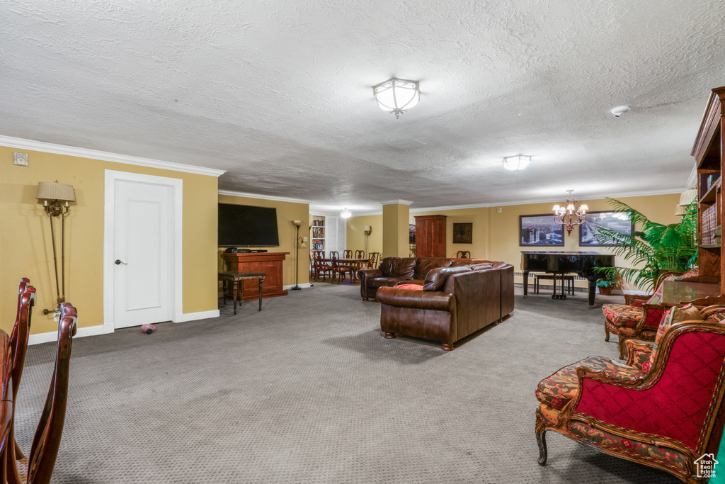 Living room featuring ornamental molding, a chandelier, carpet floors, and a textured ceiling