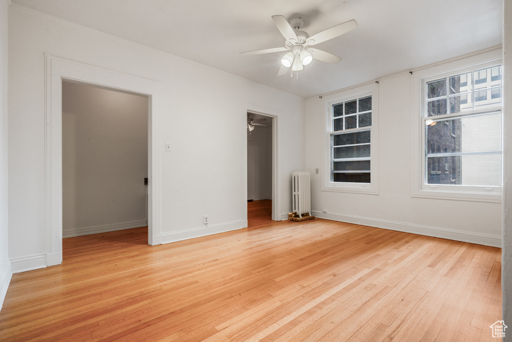 Spare room featuring ceiling fan, light hardwood / wood-style floors, and radiator