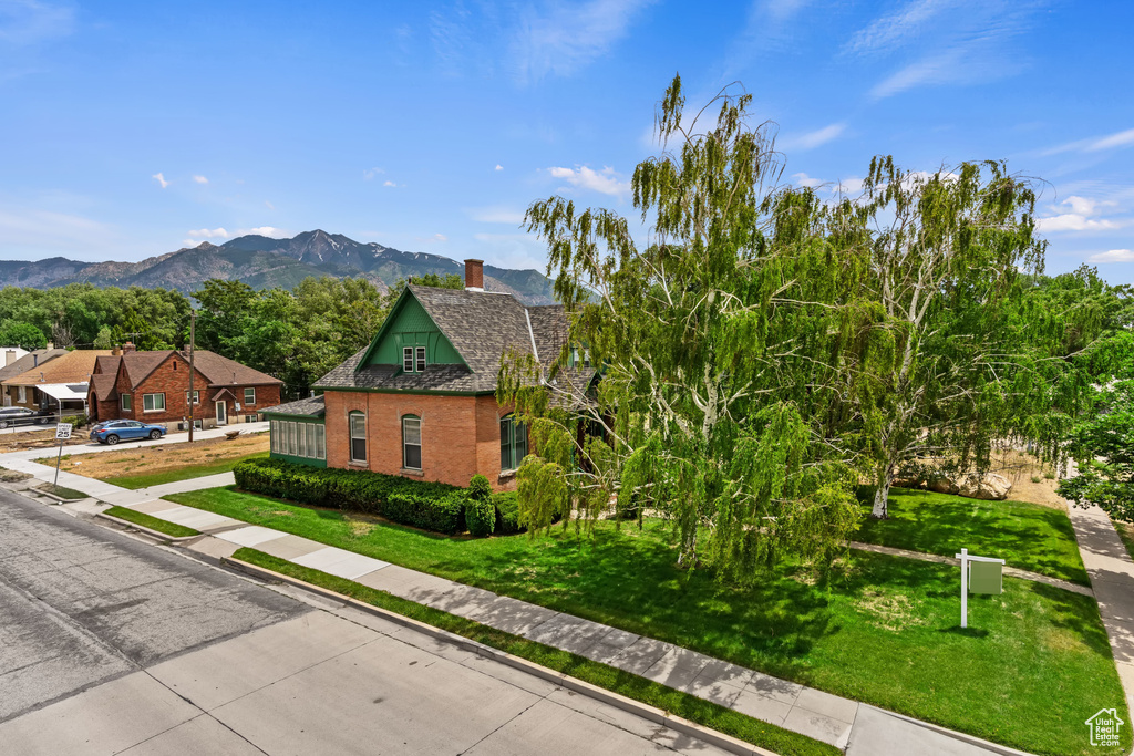View of front of property with a front yard and a mountain view