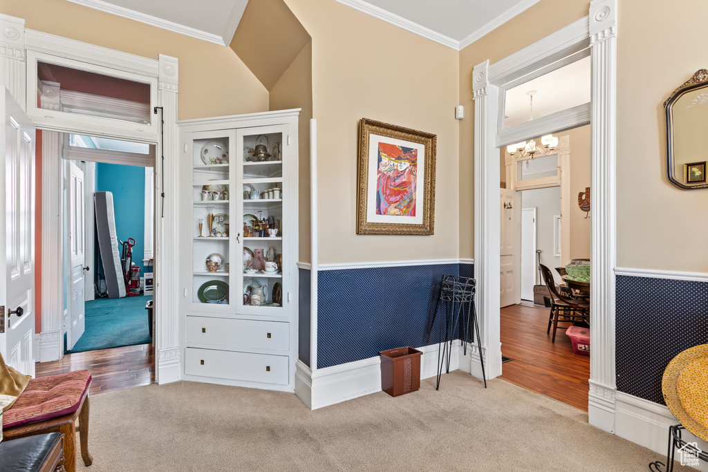 Interior space with a notable chandelier, light hardwood / wood-style floors, and crown molding