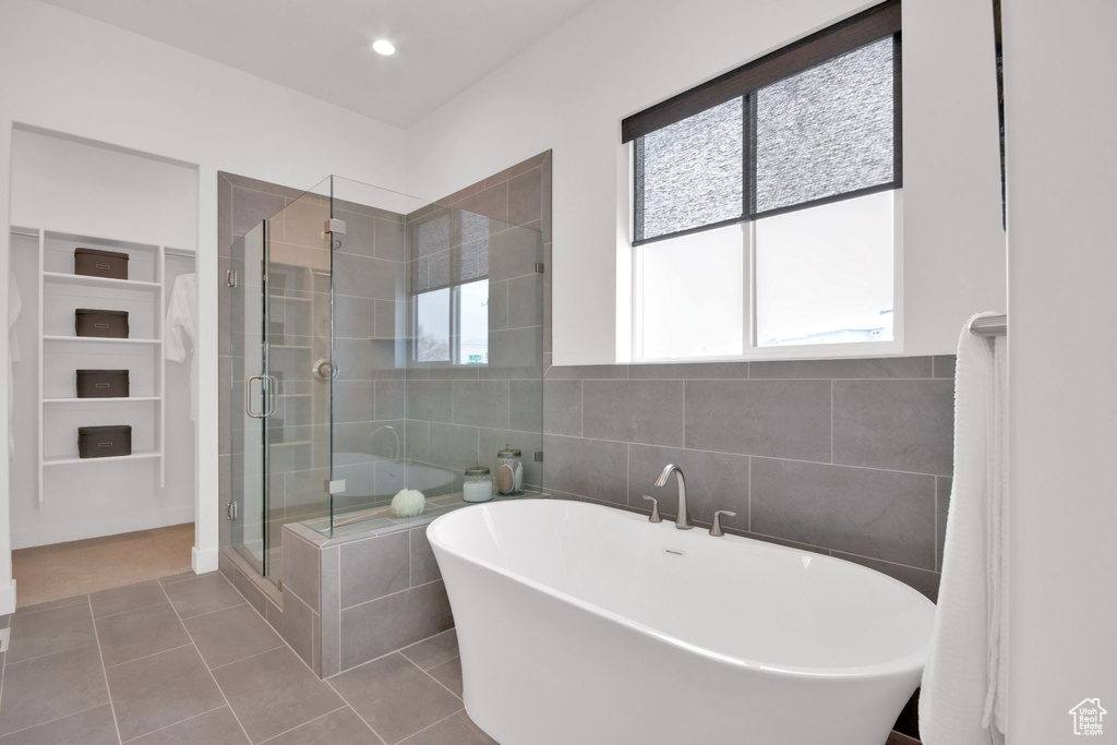 Bathroom featuring a wealth of natural light, tile flooring, and independent shower and bath