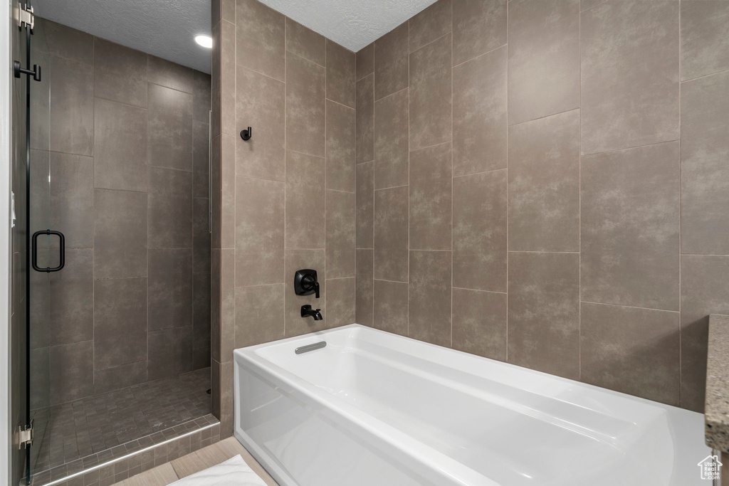 Bathroom with a textured ceiling and plus walk in shower