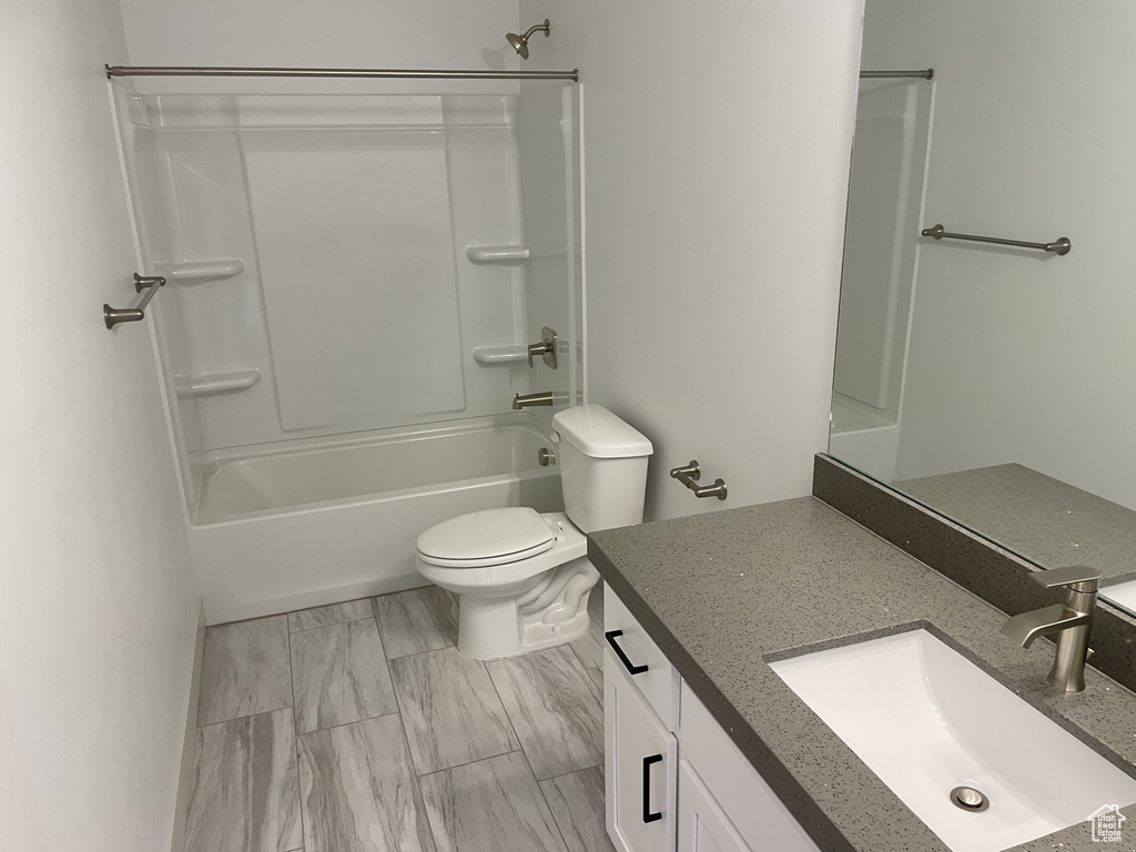 Full bathroom with toilet, vanity, and shower / tub combination