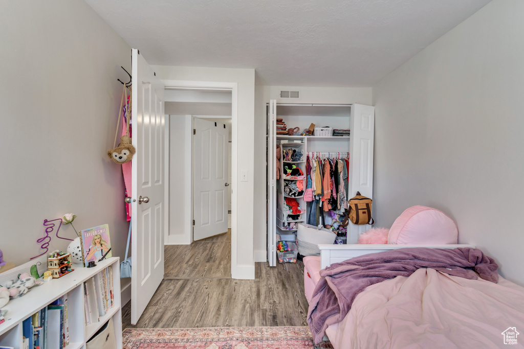 Bedroom with a closet and light hardwood / wood-style floors