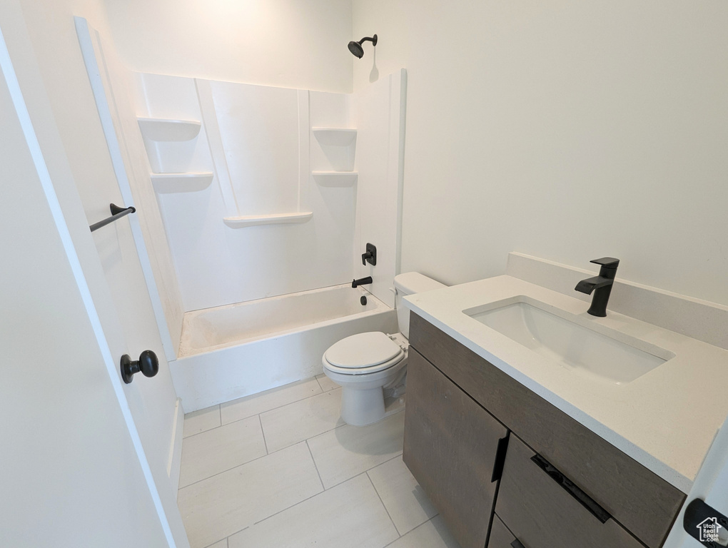 Full bathroom with tile floors, vanity, tub / shower combination, and toilet