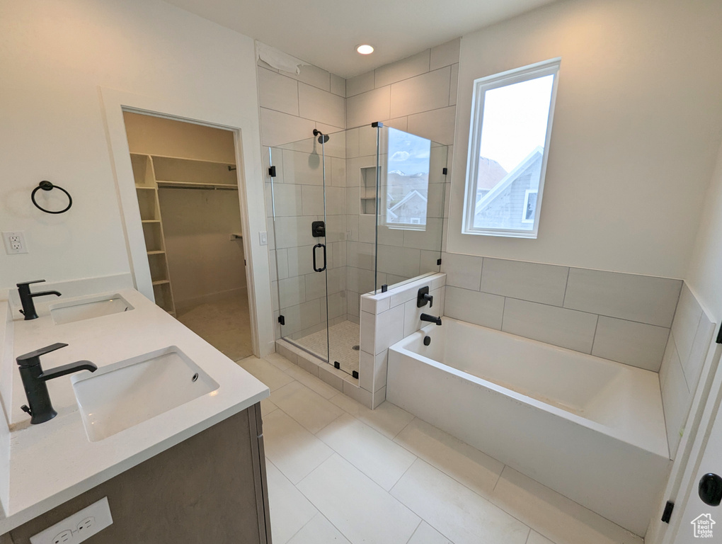Bathroom featuring plus walk in shower, tile floors, and dual vanity