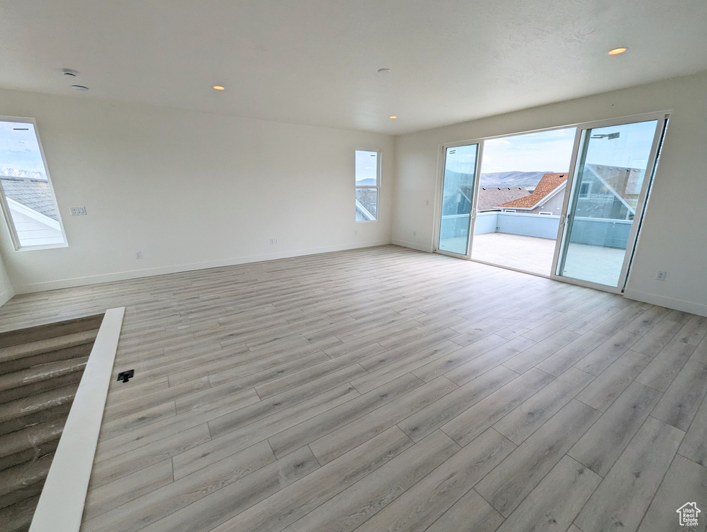 Empty room with a wealth of natural light and light hardwood / wood-style floors