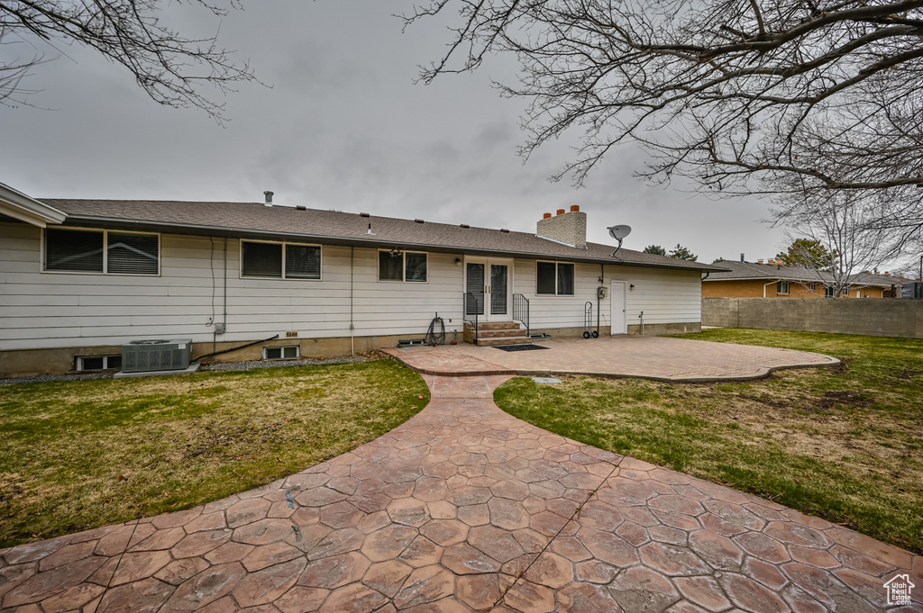 Rear view of property with a patio area, central AC, and a lawn