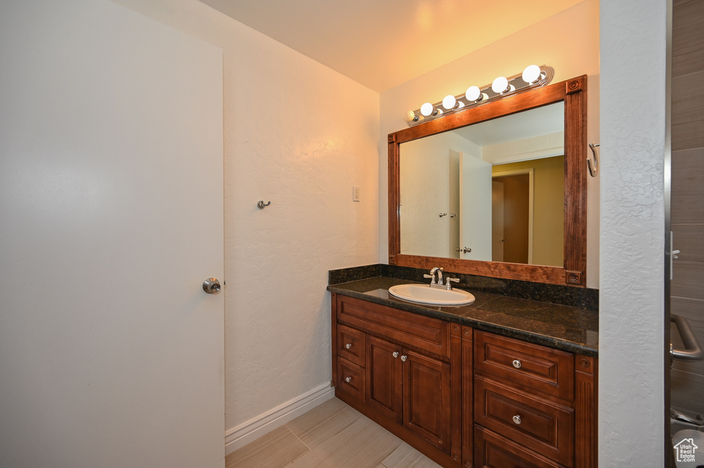 Bathroom featuring vanity with extensive cabinet space and tile flooring