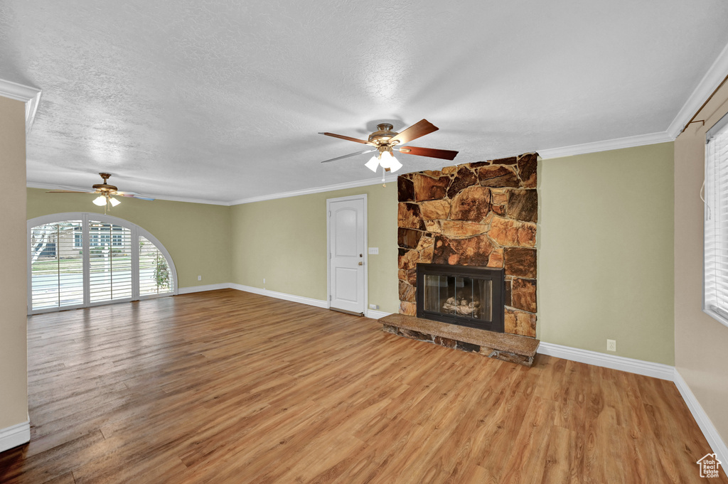 Unfurnished living room with a textured ceiling, ceiling fan, and light wood-type flooring