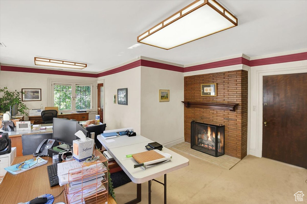 Carpeted office with ornamental molding, brick wall, and a brick fireplace