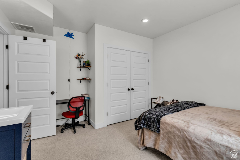 Bedroom featuring light colored carpet and a closet