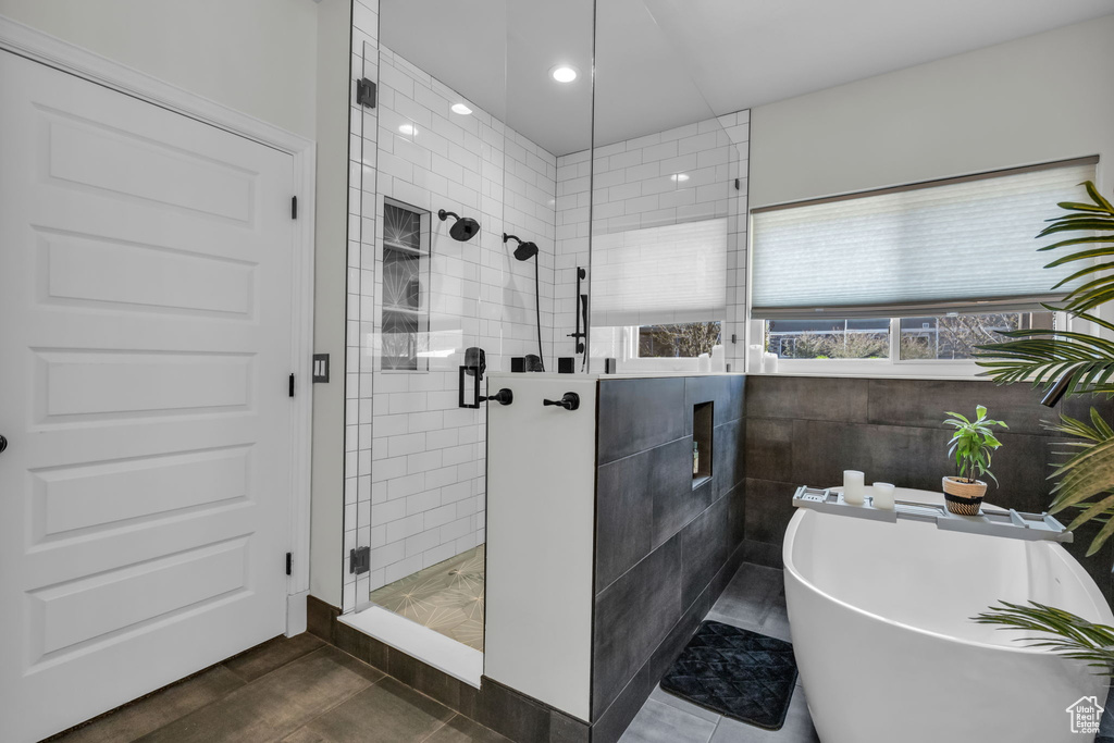 Bathroom with tile walls, plus walk in shower, and tile floors