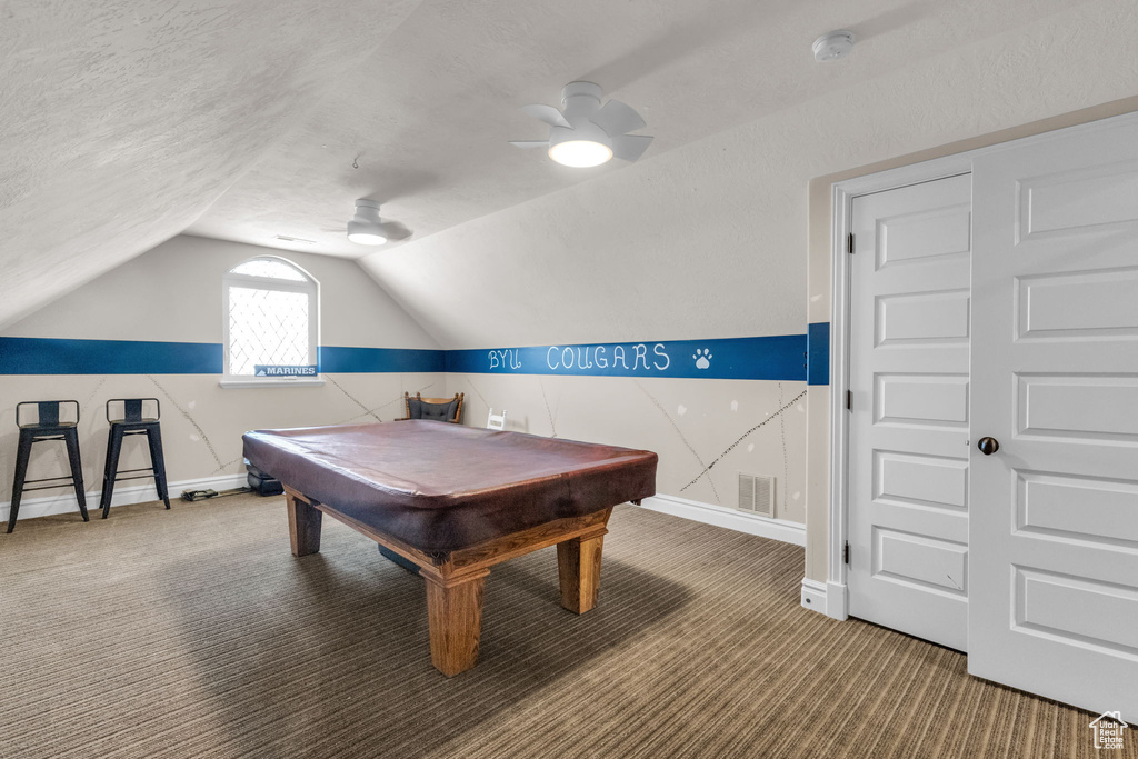 Recreation room featuring ceiling fan, billiards, a textured ceiling, lofted ceiling, and dark colored carpet