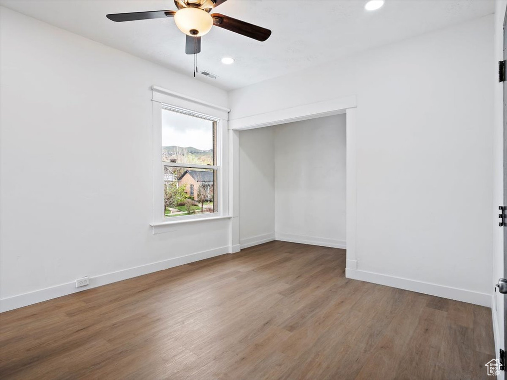 Empty room featuring ceiling fan and dark hardwood / wood-style floors
