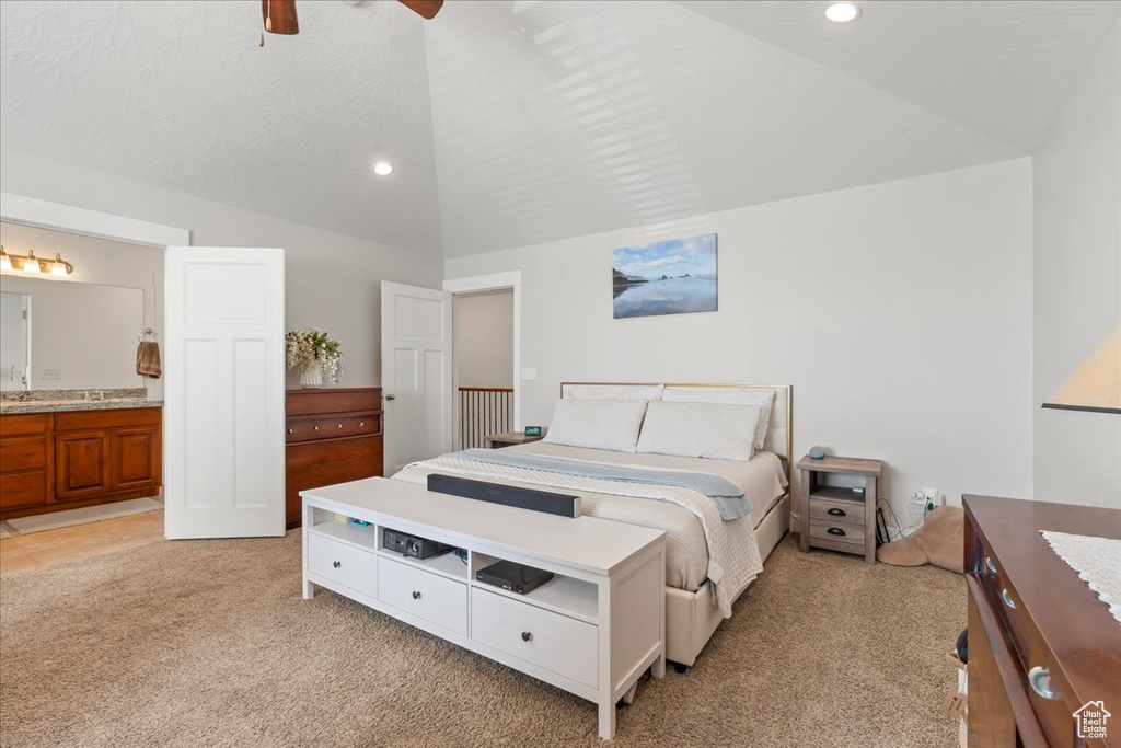 Bedroom with light colored carpet, lofted ceiling, ceiling fan, and ensuite bath