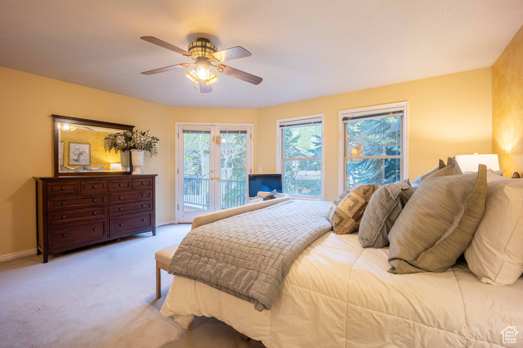 Bedroom with light carpet, ceiling fan, french doors, and access to outside