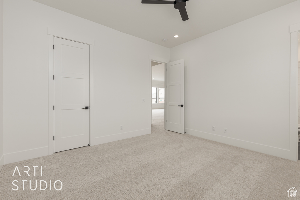 Unfurnished bedroom featuring light carpet and ceiling fan