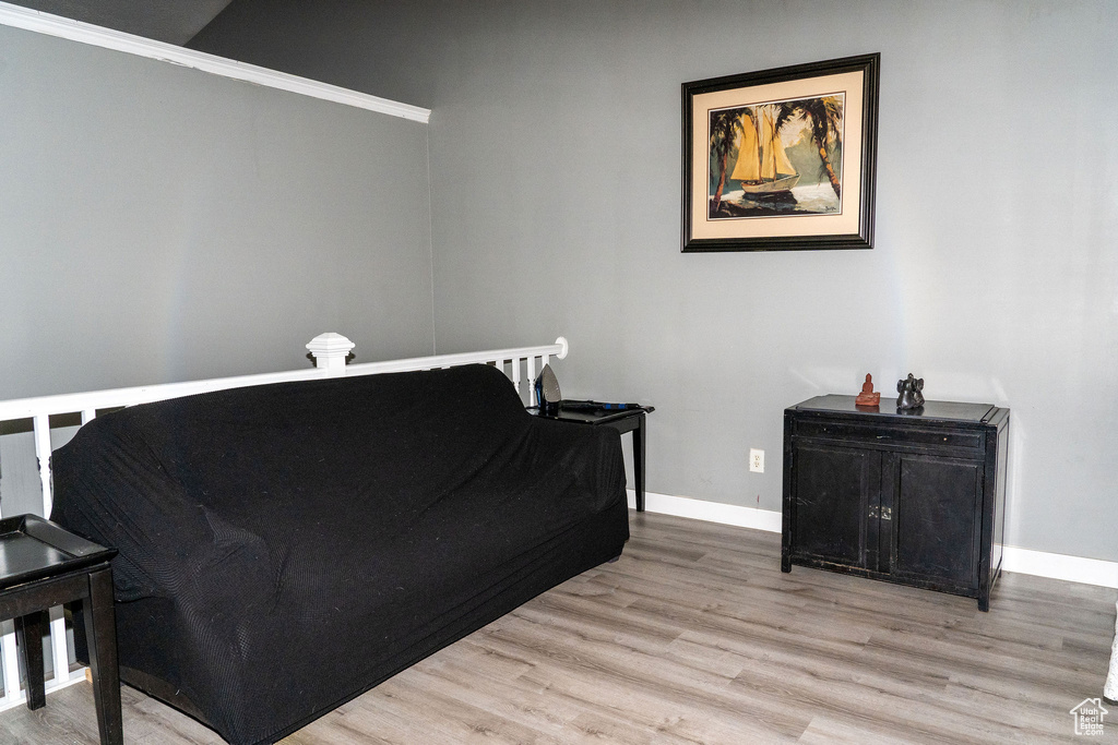Bedroom featuring ornamental molding and light hardwood / wood-style flooring