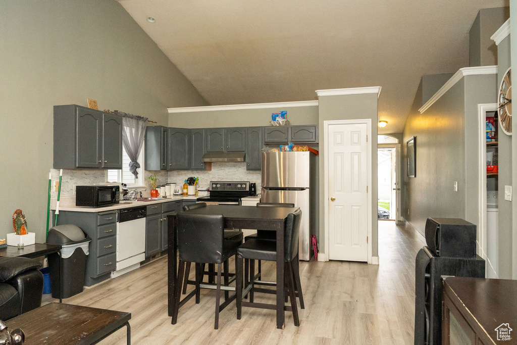 Kitchen with light wood-type flooring, stainless steel refrigerator, backsplash, white dishwasher, and electric range