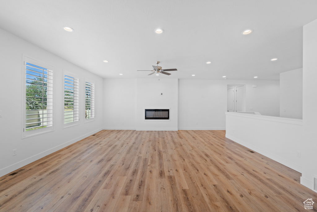 Unfurnished living room with light hardwood / wood-style flooring and ceiling fan