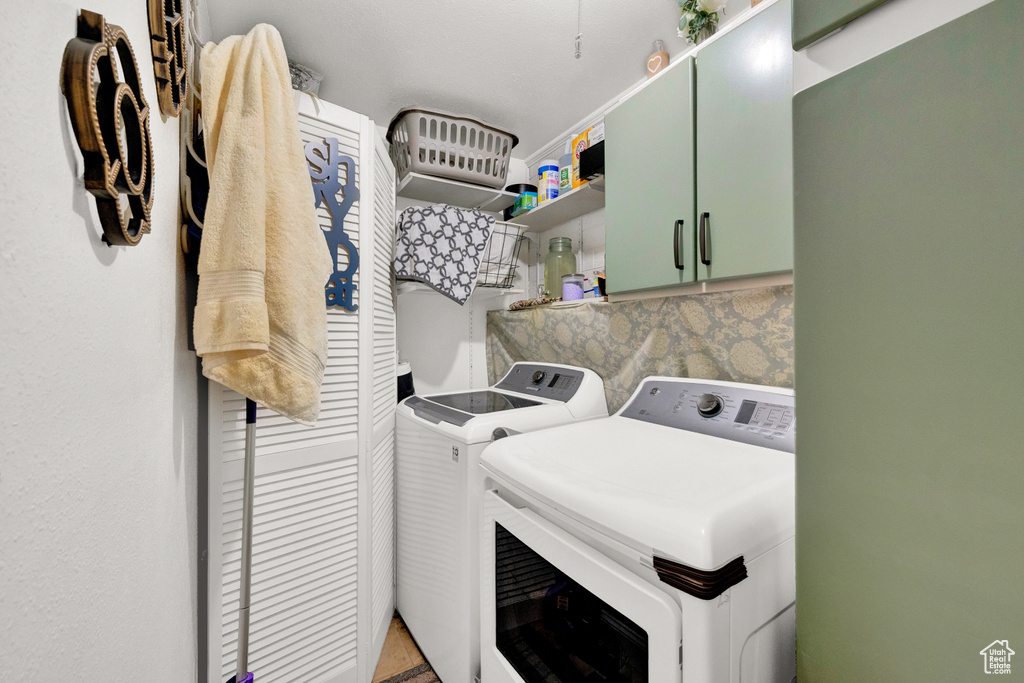 Clothes washing area featuring cabinets and independent washer and dryer