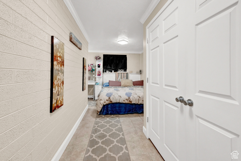 Bedroom with light tile floors and ornamental molding