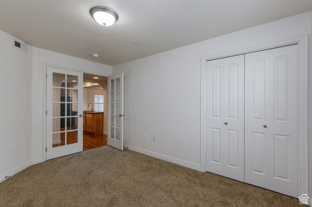 Unfurnished bedroom with a closet, french doors, and dark hardwood / wood-style floors