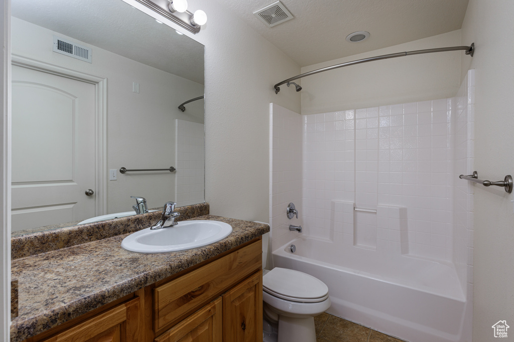 Full bathroom with oversized vanity, toilet, tile flooring, a textured ceiling, and bathing tub / shower combination