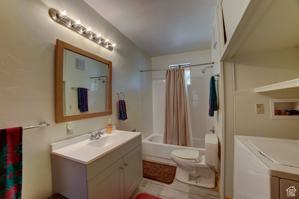 Full bathroom featuring vanity, shower / bathtub combination with curtain, tile flooring, washer / dryer, and toilet