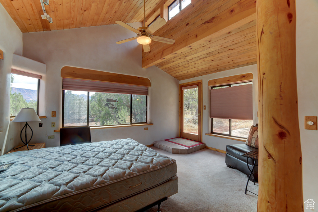 Bedroom featuring light carpet, multiple windows, and wood ceiling