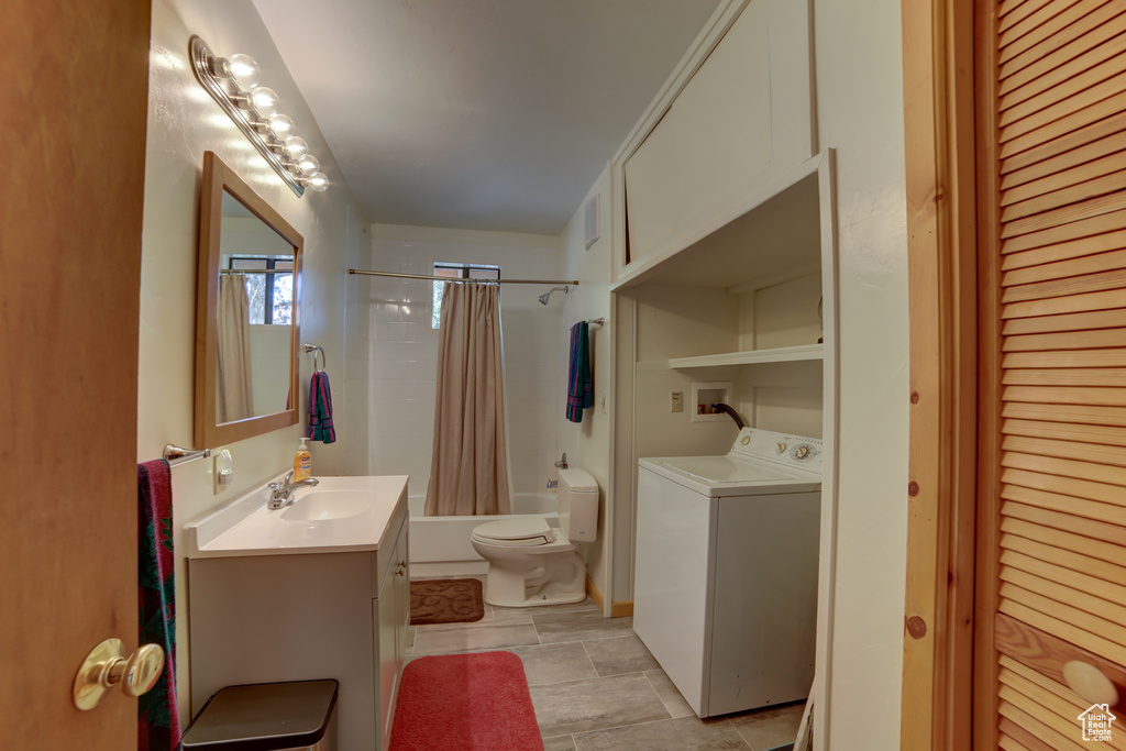 Full bathroom featuring shower / bath combination with curtain, tile floors, washer / clothes dryer, large vanity, and toilet
