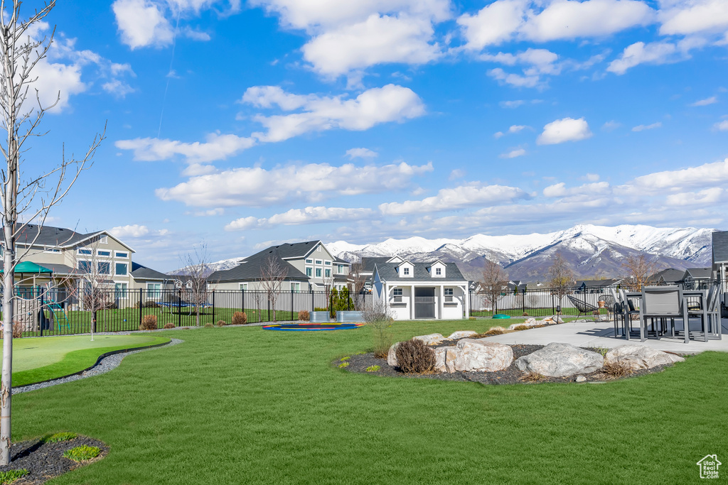 View of yard featuring a patio area, a swimming pool, a mountain view, and a playground