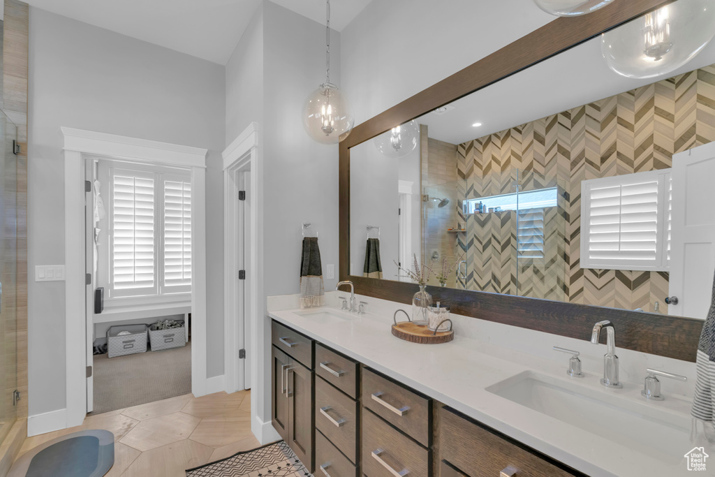 Bathroom featuring walk in shower, tile flooring, and double sink vanity